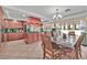 Open kitchen and dining area with wooden cabinets, tile flooring, and a kitchen island at 7520 Cobal Canyon Ln, Las Vegas, NV 89129