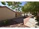 Captivating backyard features brick pavers, trees, stucco walls and a covered patio at 7624 Desert Delta Dr, Las Vegas, NV 89128