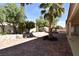 Charming backyard featuring brick pavers, mature trees, and a covered patio at 7624 Desert Delta Dr, Las Vegas, NV 89128