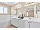 Bathroom showcasing double vanity and adjacent soaking tub at 7624 Desert Delta Dr, Las Vegas, NV 89128