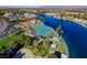 Aerial view of a community pool and recreation center with palm trees and waterfront views at 7624 Desert Delta Dr, Las Vegas, NV 89128