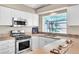 Efficient kitchen with stainless steel appliances, bright white cabinets, and a practical breakfast bar area at 7624 Desert Delta Dr, Las Vegas, NV 89128