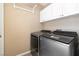 Modern laundry area with front-load washer and dryer, complemented by white cabinets at 7624 Desert Delta Dr, Las Vegas, NV 89128