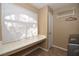 Bright laundry room with built-in counter space, shelving, and modern appliances at 7624 Desert Delta Dr, Las Vegas, NV 89128