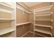 Walk-in closet with built-in shelving and tan carpeting at 7624 Desert Delta Dr, Las Vegas, NV 89128