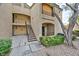 A close exterior view of a two-story condo building with access stairs and partial landscaping at 7885 W Flamingo Rd # 1016, Las Vegas, NV 89147