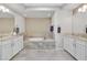 Bathroom with granite counters, white cabinets and soaking tub at 8460 Carmel Ridge Ct, Las Vegas, NV 89113