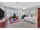 A carpeted bedroom with an expansive bank of shuttered windows for natural light, furnishings, and an ensuite bath at 8460 Carmel Ridge Ct, Las Vegas, NV 89113