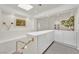 Bright hallway features built-in cabinets, decorative art, and soft natural light from a skylight at 8460 Carmel Ridge Ct, Las Vegas, NV 89113