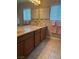 Bathroom featuring a dual sink vanity with updated lighting, framed mirror, and pink accents at 8494 Langhorne Creek St, Las Vegas, NV 89139