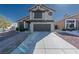 Two-story home with a desert landscape, wide driveway, and a two-car garage under a clear blue sky at 8869 Dove Cove Dr, Las Vegas, NV 89129