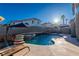 Backyard pool area featuring a spa, multiple waterfalls, shaded seating and blue skies at 8869 Dove Cove Dr, Las Vegas, NV 89129