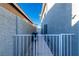 Side yard with a gray concrete wall and white metal gate to the backyard at 8869 Dove Cove Dr, Las Vegas, NV 89129