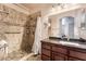 Bathroom featuring a dark wood vanity, granite counters, and a tiled shower with built-in shelves at 9000 Las Vegas Blvd # 1029, Las Vegas, NV 89123