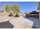 Gravel backyard features a mature tree, storage shed, covered patio, and perimeter block wall at 9678 Swaying Elms Ct, Las Vegas, NV 89147