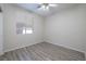 A clean bedroom featuring a modern ceiling fan, a window, and stylish wood-look flooring at 9678 Swaying Elms Ct, Las Vegas, NV 89147