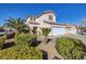 Two-story stucco home boasts a two-car garage, tile roof, and desert landscaping with palm trees and shrubs at 9678 Swaying Elms Ct, Las Vegas, NV 89147