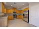 Well-lit kitchen features stainless steel appliances, granite countertops, and ample wood cabinetry and tile flooring at 9678 Swaying Elms Ct, Las Vegas, NV 89147