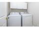 Bright laundry room with a white washer and dryer set, plus white cabinets above for storage at 9678 Swaying Elms Ct, Las Vegas, NV 89147