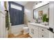 Modern bathroom featuring a shower-over-tub, vanity, and sleek navy tiling accent at 10612 Back Plains Dr, Las Vegas, NV 89134