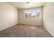 This bedroom features neutral walls, carpeted floors, and a large window that provides natural light at 1123 Scenic Crest Dr, Henderson, NV 89052