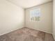 A vacant bedroom with neutral walls, carpet flooring, and a window with bright natural light at 1123 Scenic Crest Dr, Henderson, NV 89052