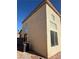 An external side view of a two-story house with stucco siding, dark trim, and rock landscaping at 1123 Scenic Crest Dr, Henderson, NV 89052