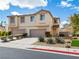 Inviting two-story townhome featuring a two-car garage, neutral stucco, and low maintenance landscaping at 1123 Scenic Crest Dr, Henderson, NV 89052