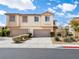 Inviting two-story townhome featuring a two-car garage, neutral stucco, and low maintenance landscaping at 1123 Scenic Crest Dr, Henderson, NV 89052