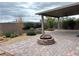 Paver patio and stone firepit with professional landscaping in backyard. Beautiful outdoor space for entertaining at 11260 Burning River St, Las Vegas, NV 89183