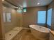 Bathroom with a glass shower and a separate soaking tub near a window at 11260 Burning River St, Las Vegas, NV 89183