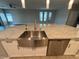 Modern kitchen island featuring a stainless steel sink and dishwasher at 11260 Burning River St, Las Vegas, NV 89183