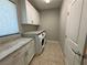 Laundry room with ample cabinet space, granite countertops, and modern washer/dryer units at 11260 Burning River St, Las Vegas, NV 89183