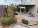 Landscaped patio with pavers, a covered area with lights, and a charming fire pit create an inviting outdoor living space at 11260 Burning River St, Las Vegas, NV 89183