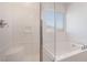 Relaxing bathroom featuring a soaking tub, glass-enclosed shower, and a window at 1338 Ossa St, Henderson, NV 89052