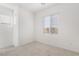 Simple bedroom with neutral carpet, two windows, and plain white walls, creating a clean and serene space at 1338 Ossa St, Henderson, NV 89052