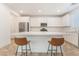 Bright, all-white kitchen featuring a large island, stainless steel appliances, and modern seating at 1338 Ossa St, Henderson, NV 89052