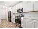 Bright kitchen with stainless steel appliances, white cabinets and quartz countertops at 1338 Ossa St, Henderson, NV 89052