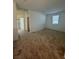 A room with neutral carpet, a window, and white door and access to various rooms at 1586 Crowned Eagle St, Las Vegas, NV 89138