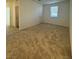 A room with neutral carpet, a window, and white door and access to various rooms at 1586 Crowned Eagle St, Las Vegas, NV 89138