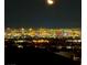 Night view of a city skyline and surrounding landscape under a half moon at 1586 Crowned Eagle St, Las Vegas, NV 89138