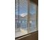 Residential window with blinds, offering views of nearby neighborhood homes and distant mountains at 1586 Crowned Eagle St, Las Vegas, NV 89138