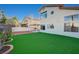 A large artificial lawn and charming landscaping in a well-kept backyard at 1800 Summit Pointe Dr, Las Vegas, NV 89117