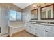 Well-lit bathroom featuring a bathtub, shower, dual sinks, and granite countertops at 1800 Summit Pointe Dr, Las Vegas, NV 89117