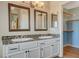 Bright bathroom featuring a double vanity with granite countertops and framed mirrors, plus a walk-in closet at 1800 Summit Pointe Dr, Las Vegas, NV 89117