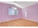 Bedroom featuring wood floors, a window with blinds, and a fresh coat of purple paint at 1800 Summit Pointe Dr, Las Vegas, NV 89117