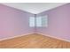 Bedroom featuring wood floors, a window with blinds, and a fresh coat of purple paint at 1800 Summit Pointe Dr, Las Vegas, NV 89117