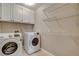 Bright laundry room with white cabinets, wire shelves, and a modern washer and dryer set at 1800 Summit Pointe Dr, Las Vegas, NV 89117