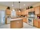 Traditional eat-in kitchen with wooden cabinets, tile floors, white countertops, and modern appliances at 1811 Tiger Creek Ave, Henderson, NV 89012