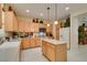 Traditional kitchen with wooden cabinets, central island, tile floors, and modern appliances at 1811 Tiger Creek Ave, Henderson, NV 89012